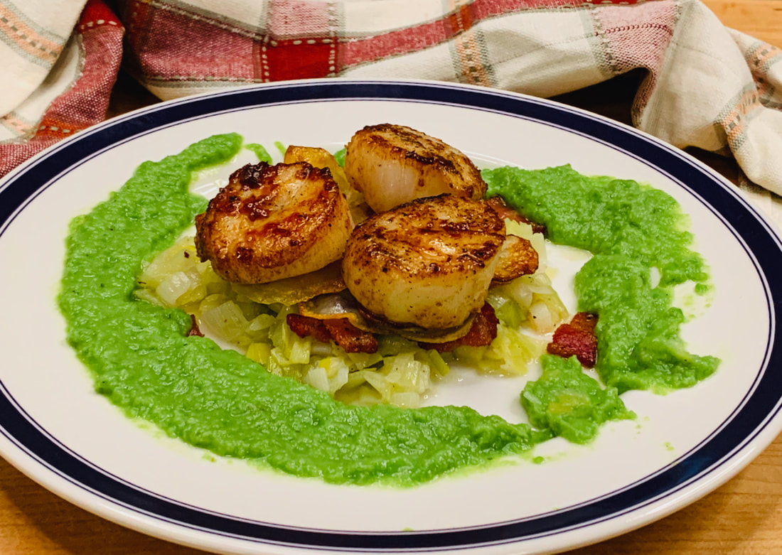 Scallops on potato galettes with leeks and peas